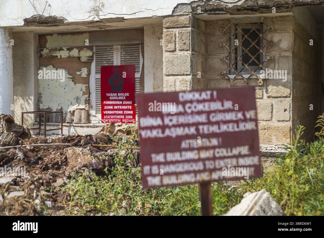 Varosha, Chypre - 25 juin 2025 : vue d'un bâtiment en décomposition avec des panneaux d'avertissement, sa façade en ruine rappelant brutalement le passage incessant du temps. Banque D'Images