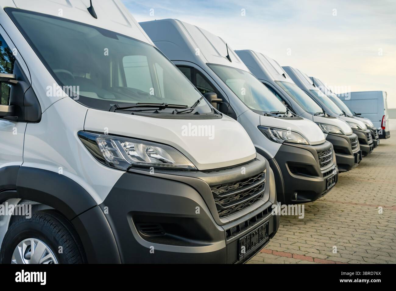 Camionnettes de livraison commerciales parking dans une rangée, transport et compagnie de service d'expédition Banque D'Images