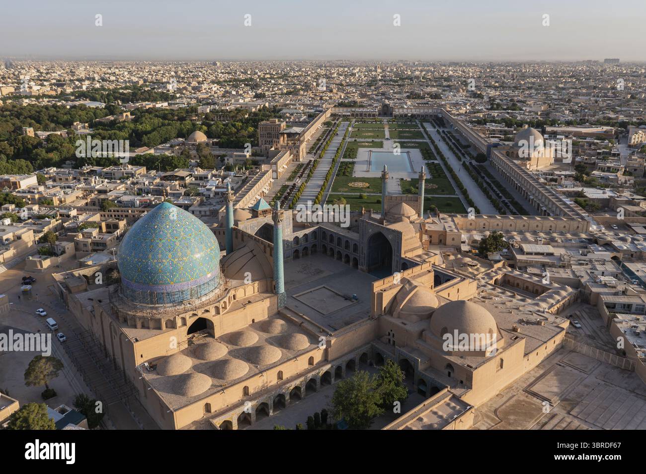 La vue aérienne du dôme envoûtant de carreaux bleus de la mosquée Shah contraste avec les teintes dorées de la place Naqsh-e Jahan, une tapisserie d'histoire et de vi Banque D'Images