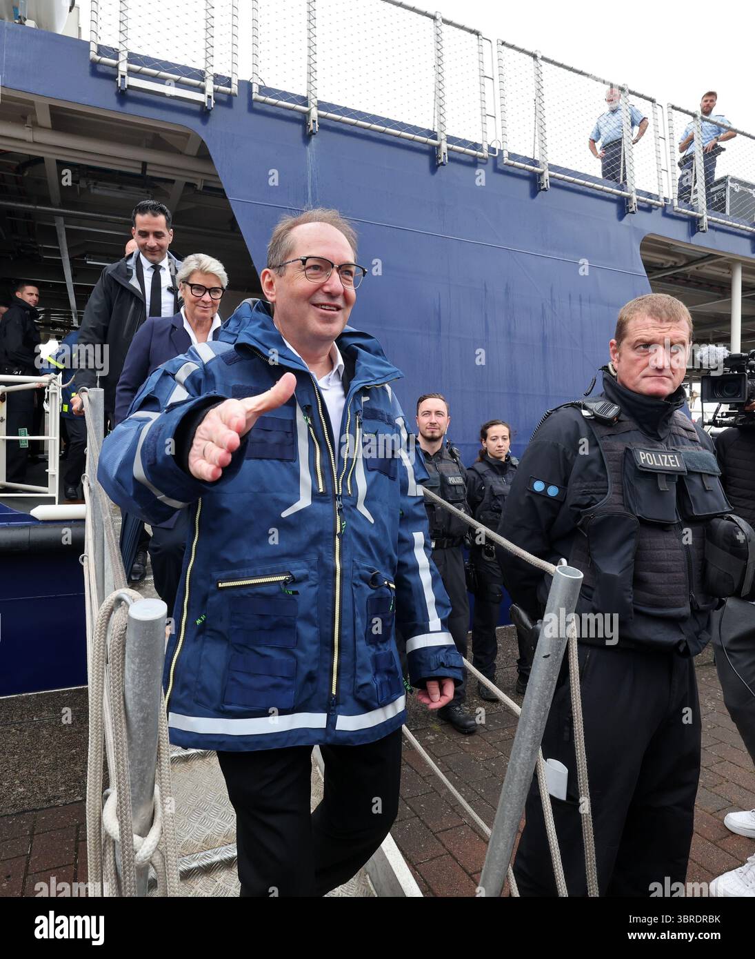 Rostock, Allemagne. 12 juillet 2025. Alexander Dobrindt (CSU), ministre fédéral de l'intérieur, débarque du navire de la police fédérale 'BP 82 Bamberg' et part pour une visite de la Journée nationale de la protection civile dans le port de la ville hanséatique. Environ 40 acteurs des secteurs de l’incendie, de la protection civile et de la lutte contre les catastrophes fourniront des informations sur leur travail. Rostock est la troisième ville après Potsdam et Wiesbaden à accueillir la journée, qui cette fois a la devise « eau - utiliser les ressources, maîtriser les risques. Crédit : Bernd Wüstneck/dpa/Alamy Live News Banque D'Images