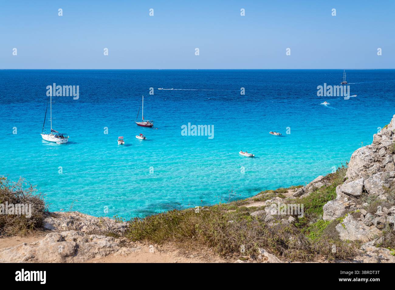 Bateaux et jet skis apprécient les eaux turquoises au large de la côte rocheuse. Favignana, Cala Rossa Banque D'Images