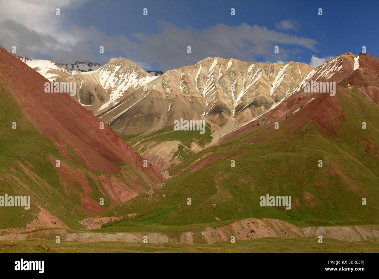 Vallée de Pamir-Alay à couper le souffle près du camp de base de Lenin Peak., Kirghizistan. Vaste paysage de montagne dans les tons rouge, vert et brun avec des taches de neige à 3600 M. Banque D'Images
