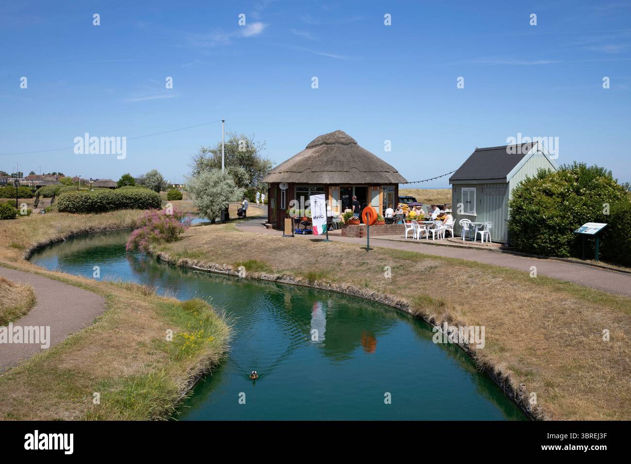 Un café-restaurant au toit de chaume sur le parc paysager des voies navigables vénitiennes près de la plage dans la station balnéaire de Great Yarmouth Banque D'Images