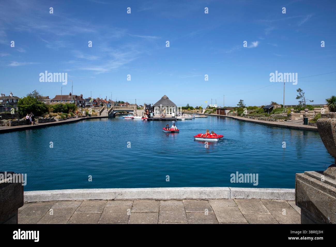 Pédalos et bateaux à rames sur le lac nautique dans la station balnéaire de Great Yarmouth. Au centre du lac se trouve le café-restaurant au toit de chaume. Banque D'Images
