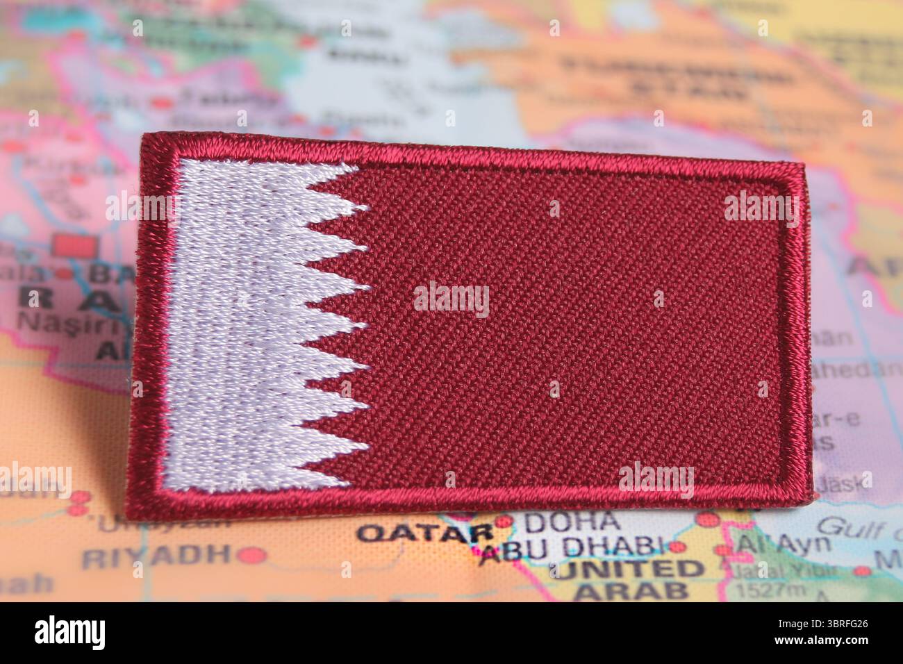 Tissu écologique drapeau du Qatar placé sur la carte du monde à son emplacement en Asie, promouvant une identité durable et la sensibilisation au voyage responsable. Banque D'Images