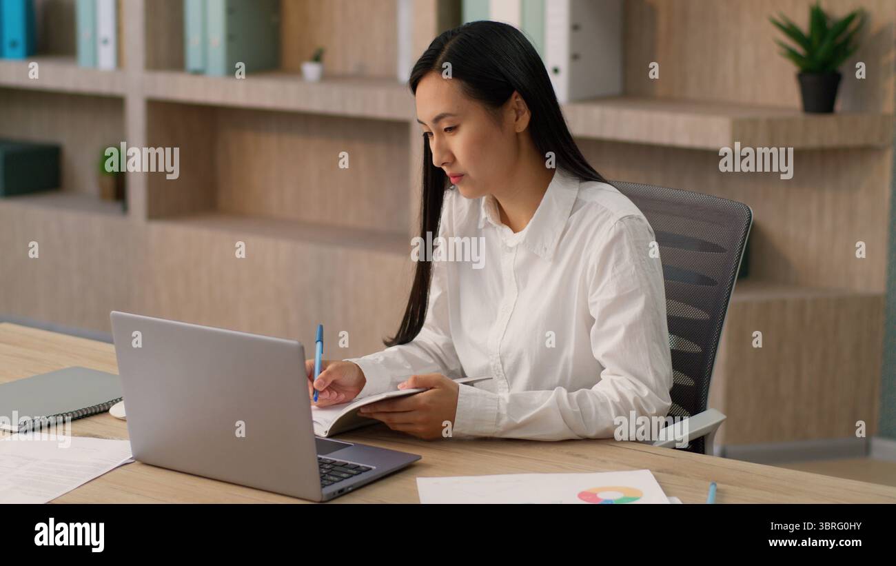 Sérieux attentif asiatique femme coréenne travailleuse japonaise fille gestionnaire d'entreprise secrétaire femme d'affaires utilisant l'entreprise de conférence vidéo d'appel portable Banque D'Images