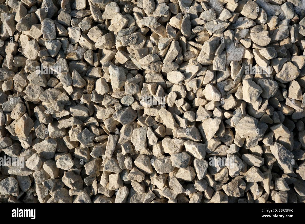 De petites pierres déchiquetées couvrent le sol sous la lumière du soleil. Banque D'Images