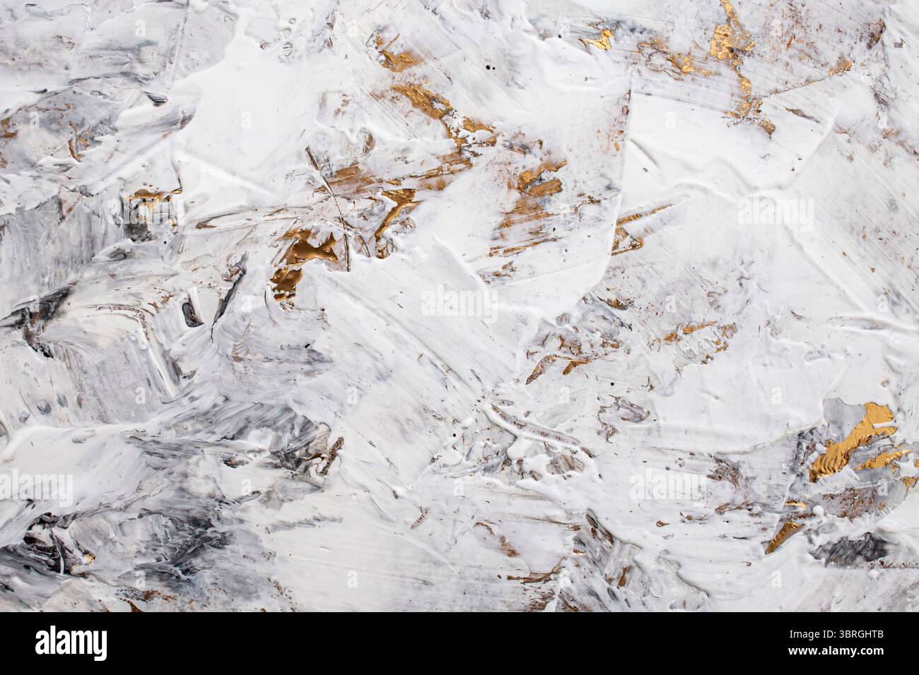 Pâte blanche mastic mélangée à de l'encre noire, détail abstrait gros plan des coups de spatule sur la rénovation de stuc de peinture dorée, Banque D'Images