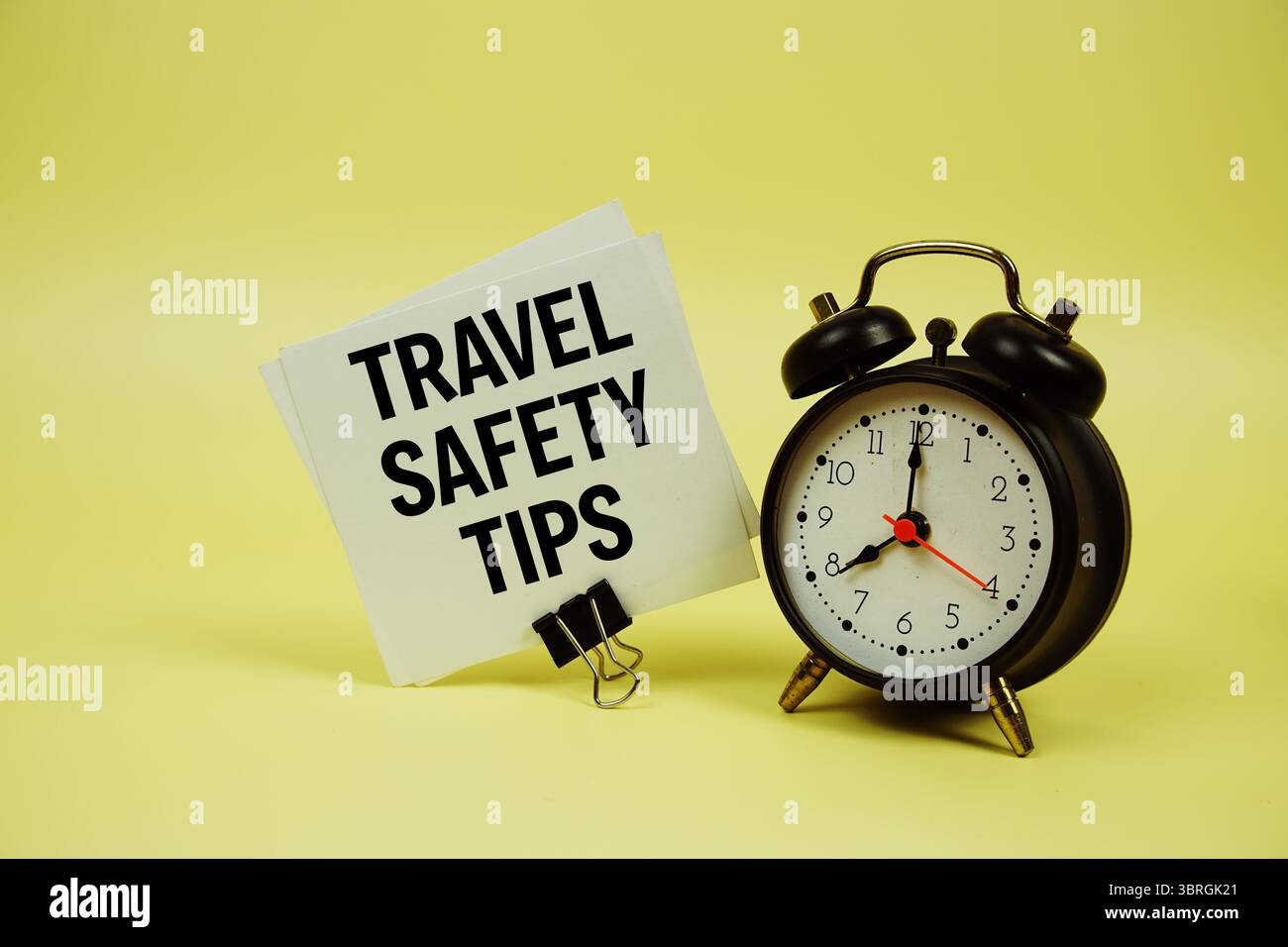 Conseils de sécurité pour les voyages message texte sur carte papier avec cliquetis d'alarme sur fond jaune Banque D'Images