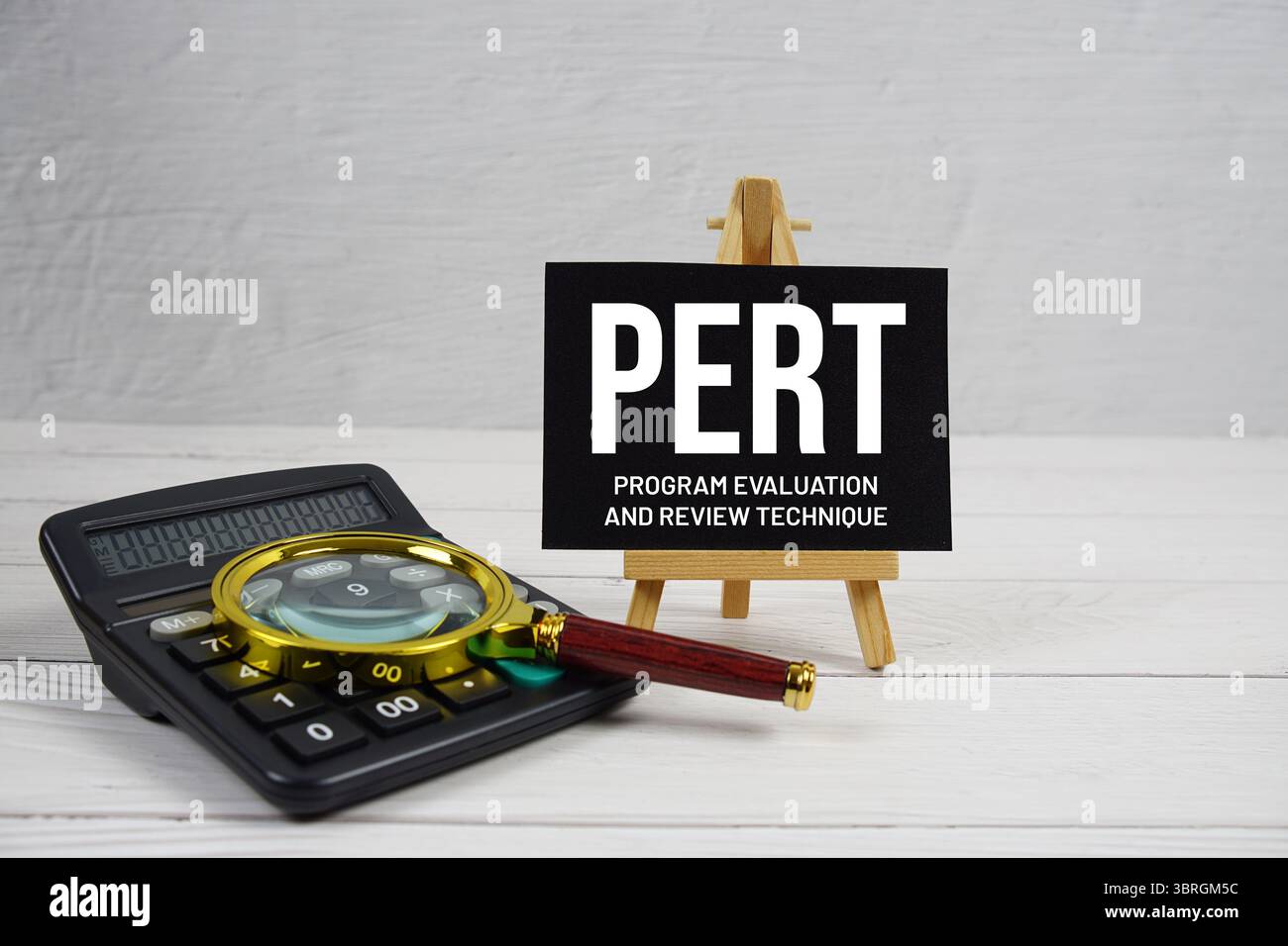 PERT abréviation de Program Evaluation and Review technique text avec loupe et calculatrice sur fond de bois Banque D'Images