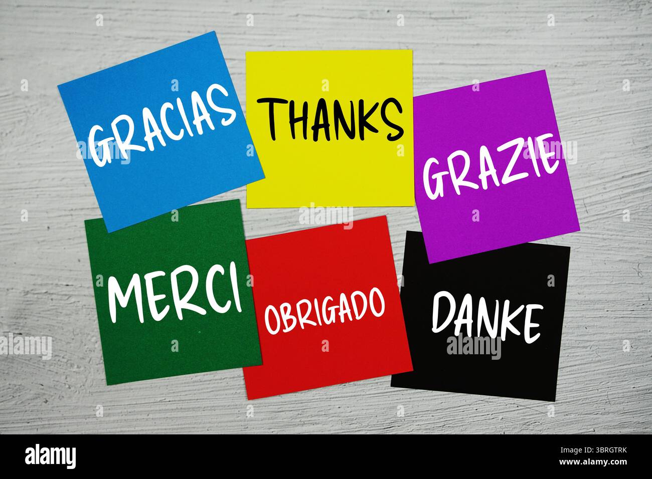 Merci dans différentes langues texte sur bâton note sur fond concret Banque D'Images