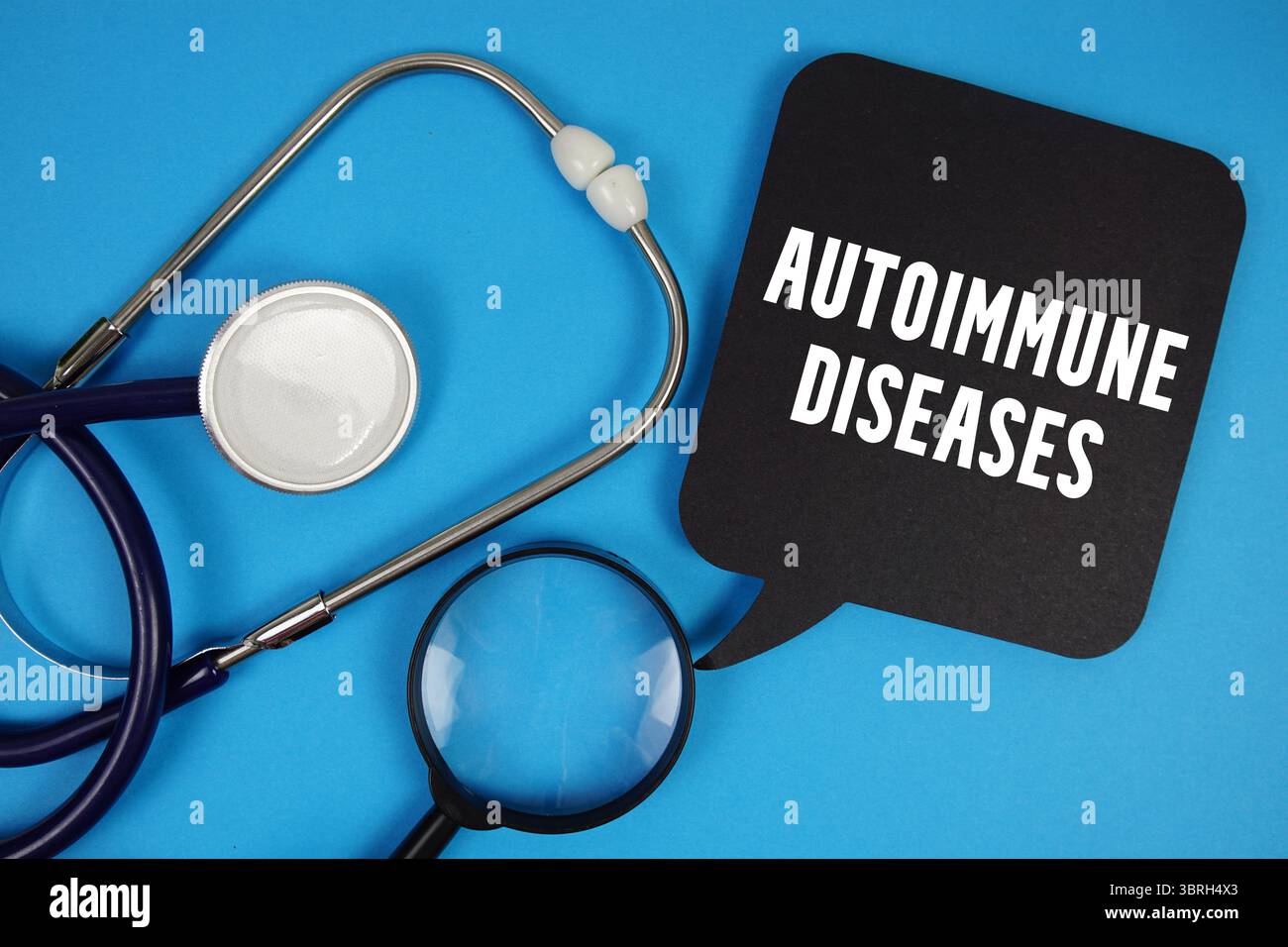 Texte maladies auto-immunes avec stéthoscope et loupe sur fond bleu Banque D'Images Texte maladies auto-immunes avec stéthoscope et loupe sur fond bleu Banque D'Images