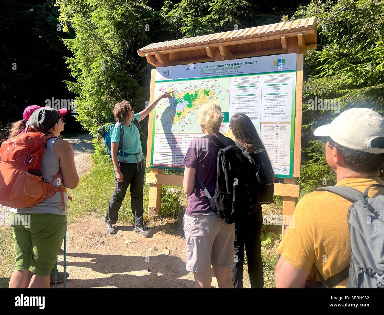 Guide féminin et randonneurs au panneau de carte d'information dans la réserve naturelle de Rila et parc national, montagne de Rila, Bulgarie, Balkans, Europe du Sud-est - Image de stock capturée avec un smartphone Guide féminin et randonneurs au panneau de carte d'information dans la réserve naturelle de Rila et parc national, montagne de Rila, Bulgarie, Balkans, Europe du Sud-est - Image de stock capturée avec un smartphone