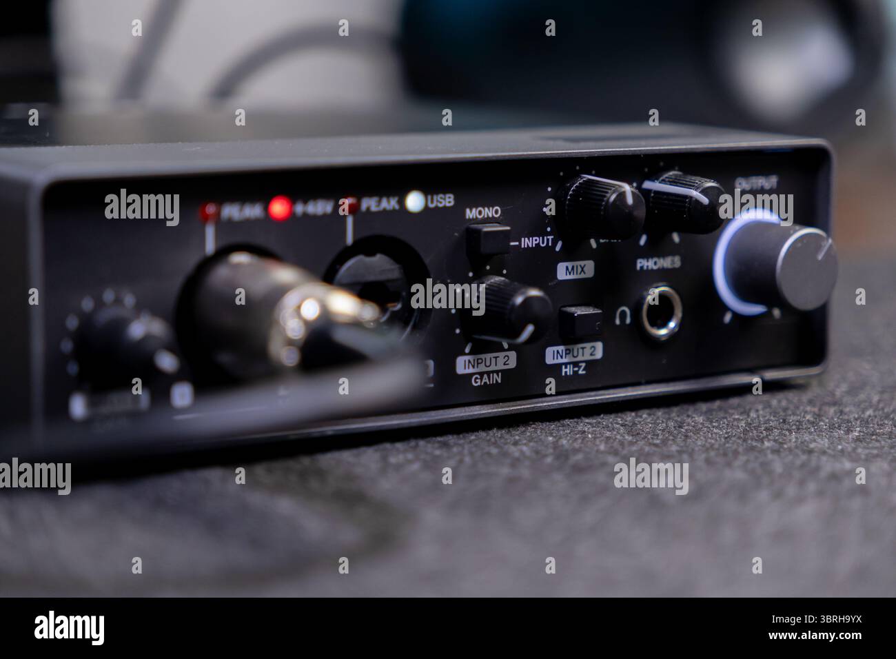 Vue détaillée d'une carte son professionnelle avec un indicateur lumineux de 48V, des boutons de commande pour L'ENTRÉE et LE MIXAGE, prenant en charge l'enregistrement à domicile et podcastin Banque D'Images