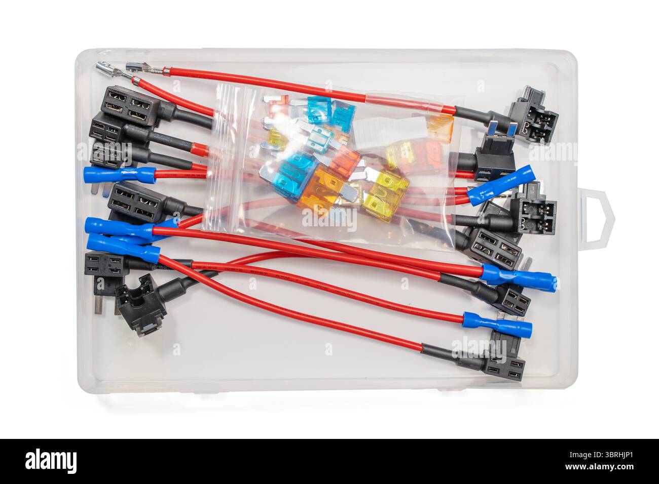 Assortiment de prises de fusibles et de fusibles à lame soigneusement organisés dans une boîte en plastique. L'ensemble du kit est isolé sur un fond blanc. Banque D'Images
