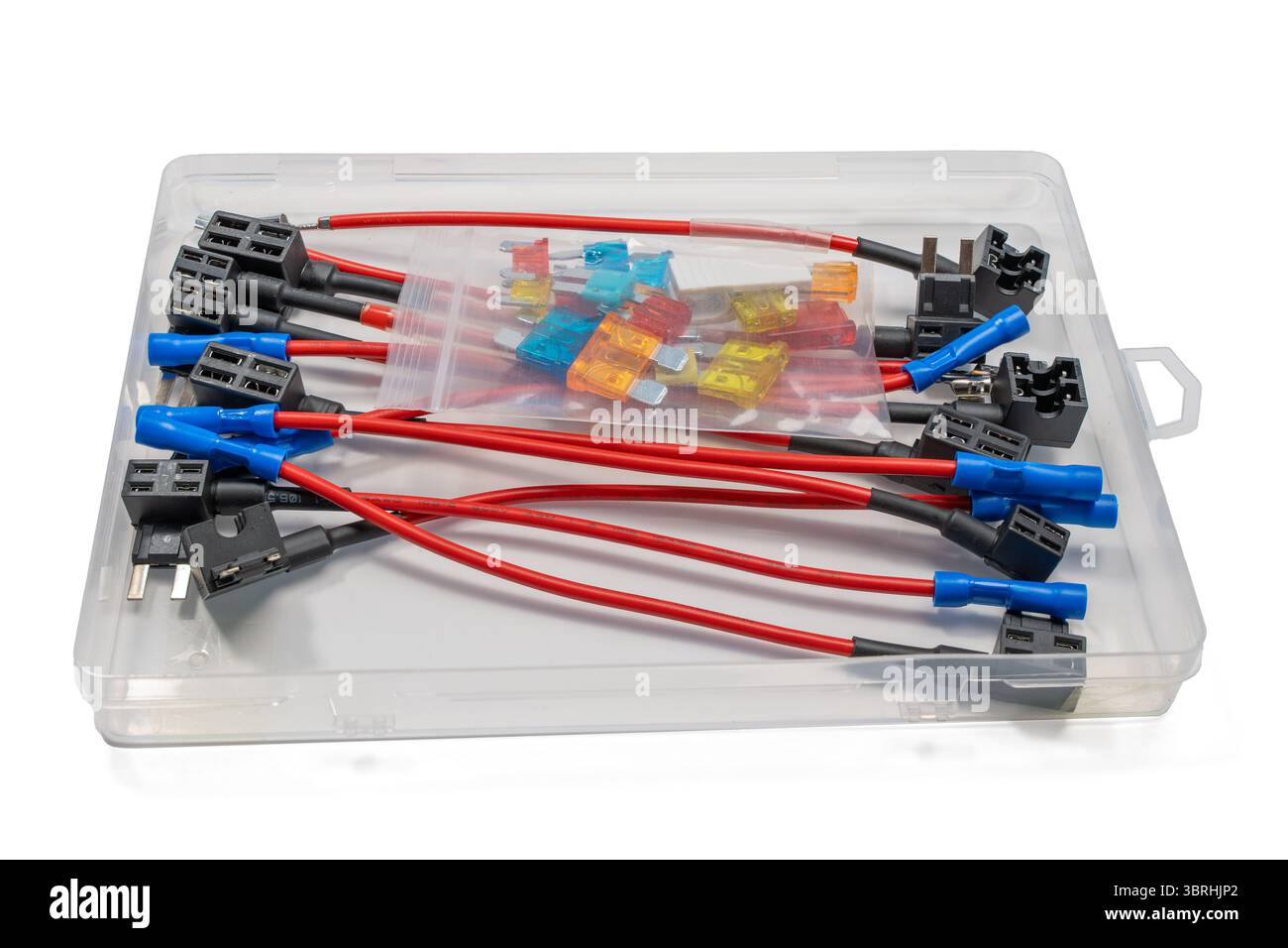 Un kit de prises de fusibles avec fils rouges, connecteurs bleus et fusibles à lame assortis. Les composants sont disposés dans un boîtier transparent, isolé sur un fond blanc Banque D'Images