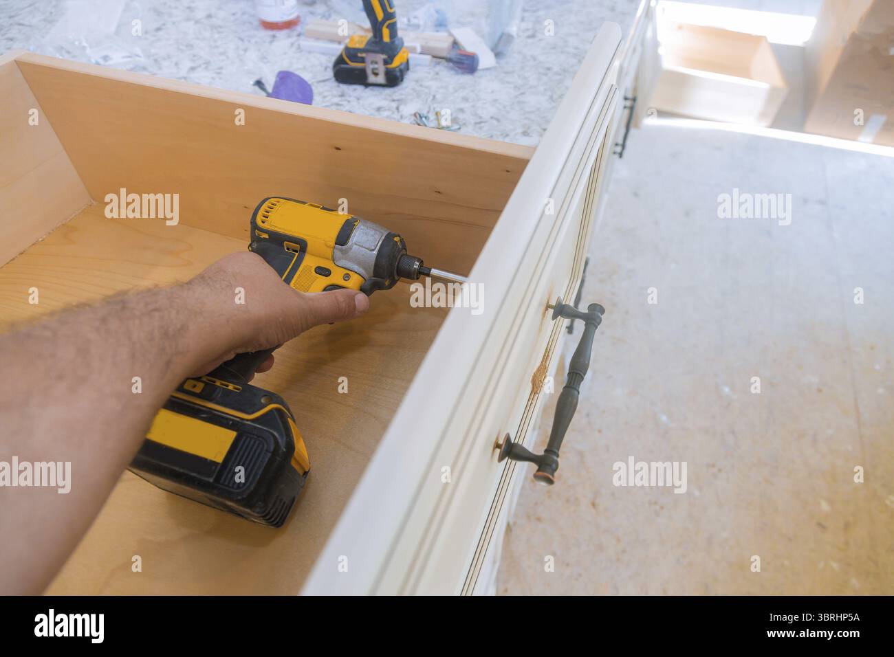 L'installation de poignées de tiroirs de mesure armoires de cuisine Banque D'Images