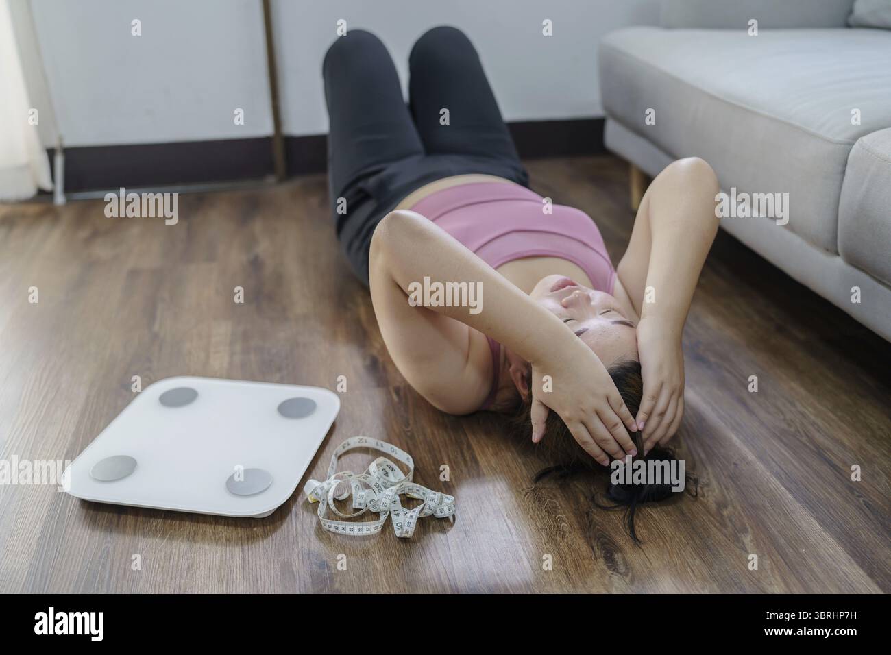 Femme obèse avec le dérangement de graisse ennuyé de régime perte de poids échouer le régime gras et l'échelle triste femme asiatique sur l'échelle de poids à la maison contrôle de poids Banque D'Images