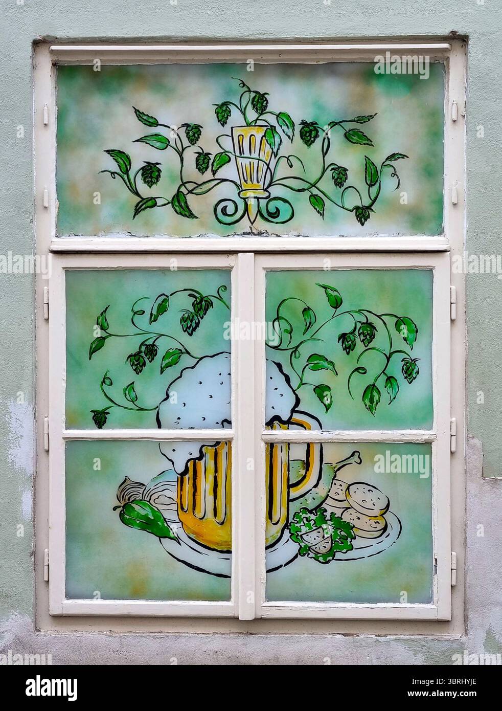 Peinture sur vitre avec un effet de vitrail représentant une tasse avec de la bière tchèque et des collations traditionnelles à Prague, République tchèque Banque D'Images