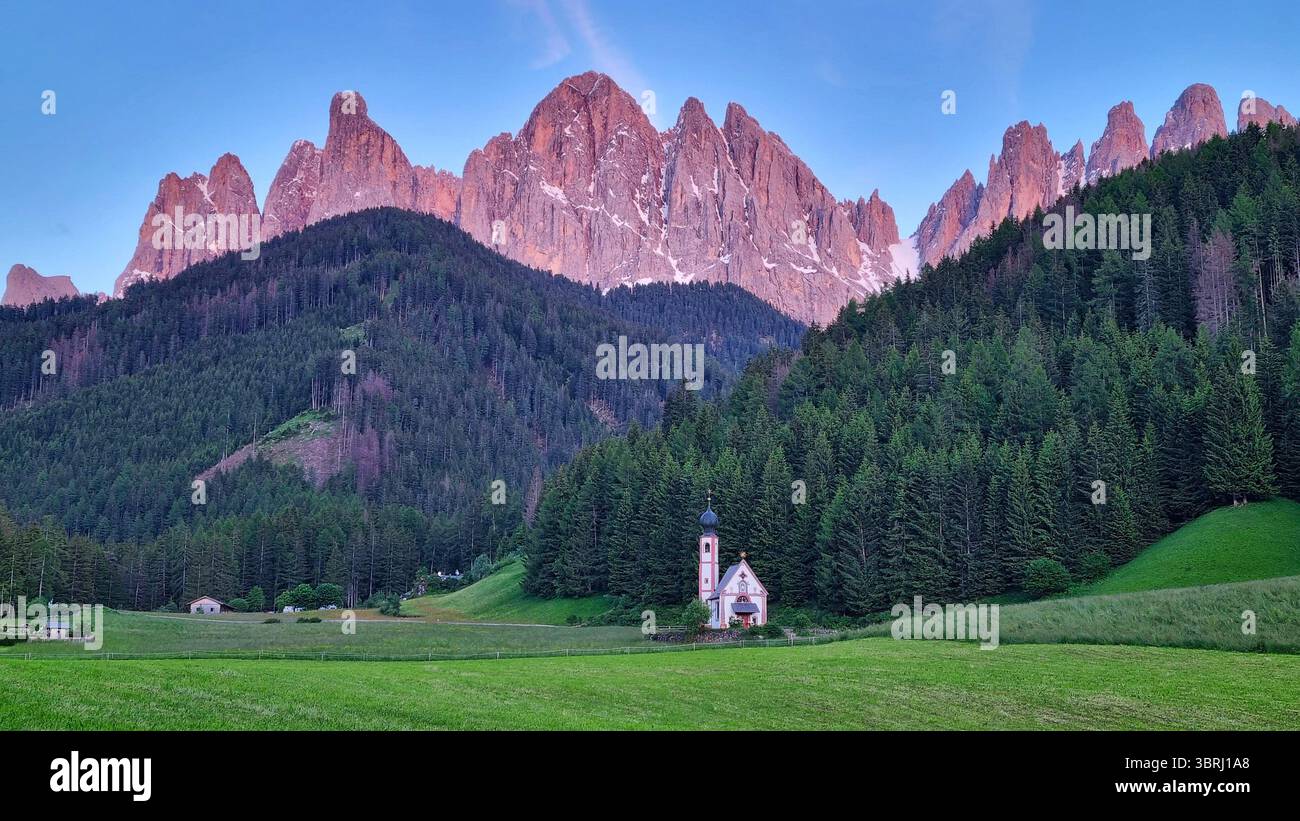 Paysage avec la célèbre chapelle de San Giovanni et la crête rouge foncé d'Odle dans les derniers rayons de coucher de soleil dans la vallée de Funes. Dolomites, Italie Banque D'Images