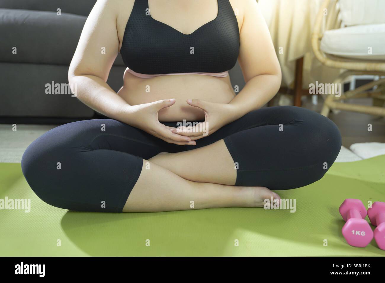 Femme en surpoids exerçant pour perdre du poids. Exercice avec des haltères dans des positions d'étirement à la maison dans le salon joyeux Fat Woman santé diététique Banque D'Images