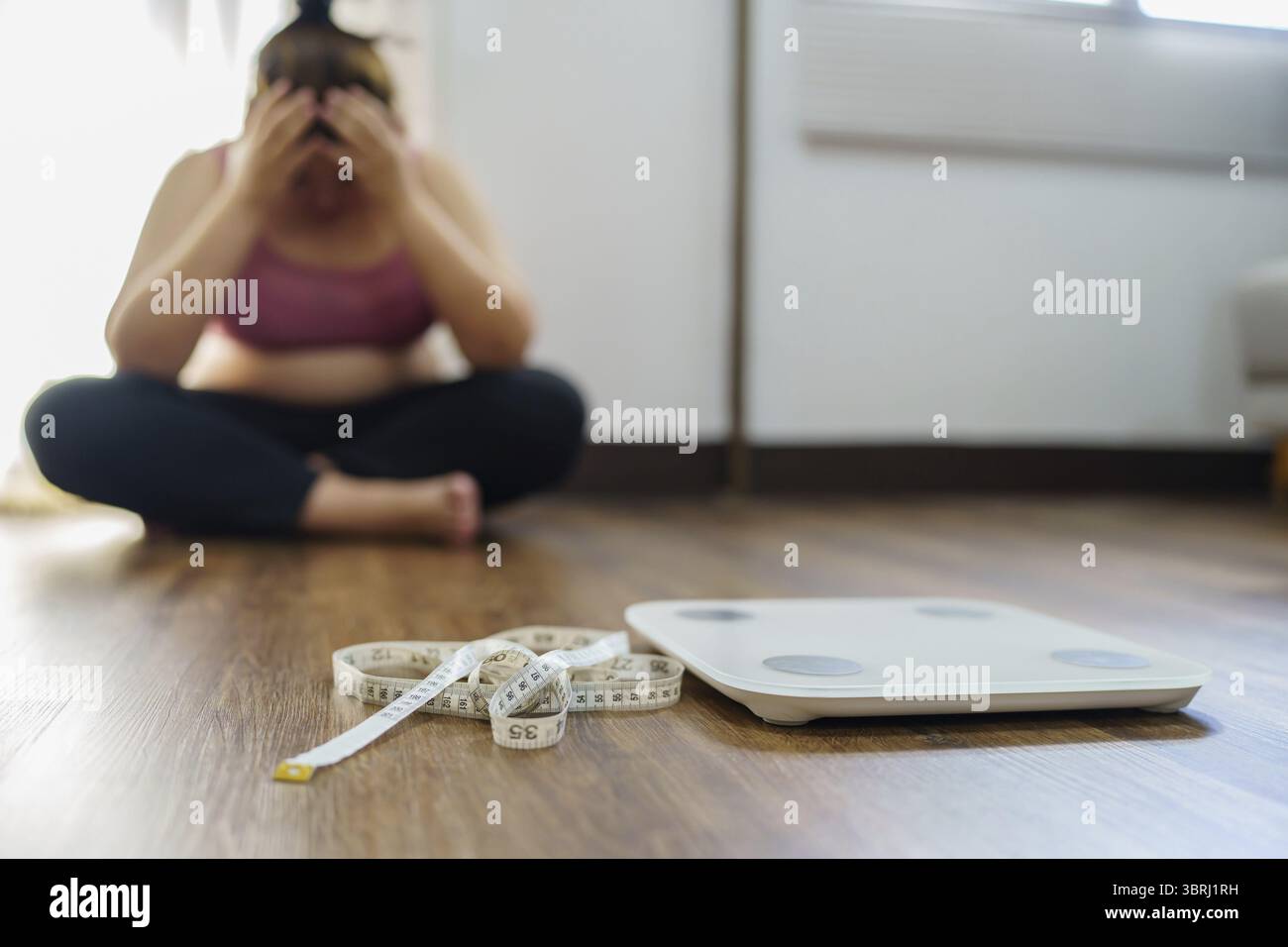 Femme obèse avec le dérangement de graisse ennuyé de régime perte de poids échouer le régime gras et l'échelle triste femme asiatique sur l'échelle de poids à la maison contrôle de poids Banque D'Images