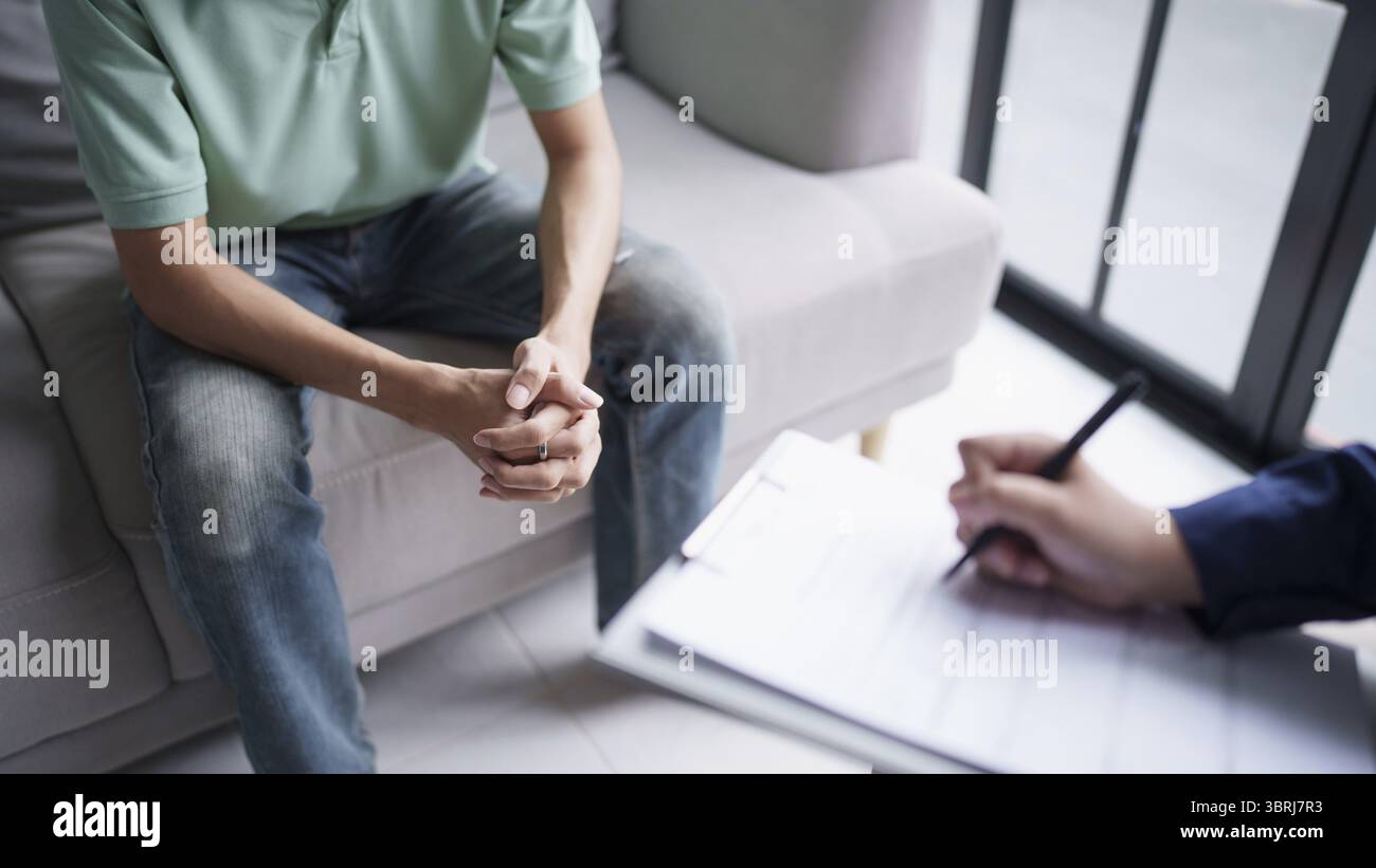 Homme triste assis sur le sofa patient discutant des problèmes de santé mentale avec le psychologue. concept de traitement de la santé mentale de l'homme asiatique déprimé Banque D'Images
