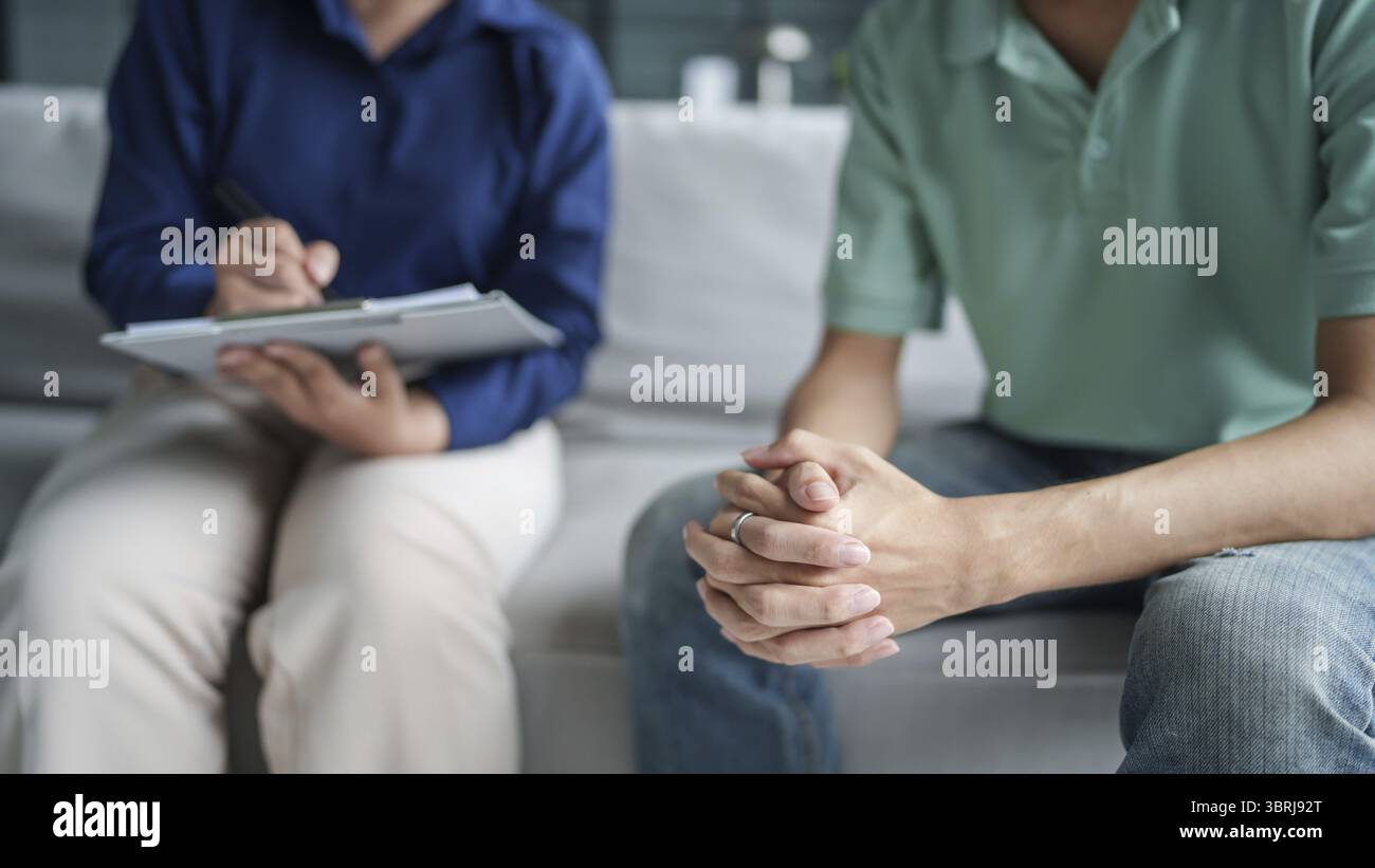 Homme triste assis sur le sofa patient discutant des problèmes de santé mentale avec le psychologue. concept de traitement de la santé mentale de l'homme asiatique déprimé Banque D'Images