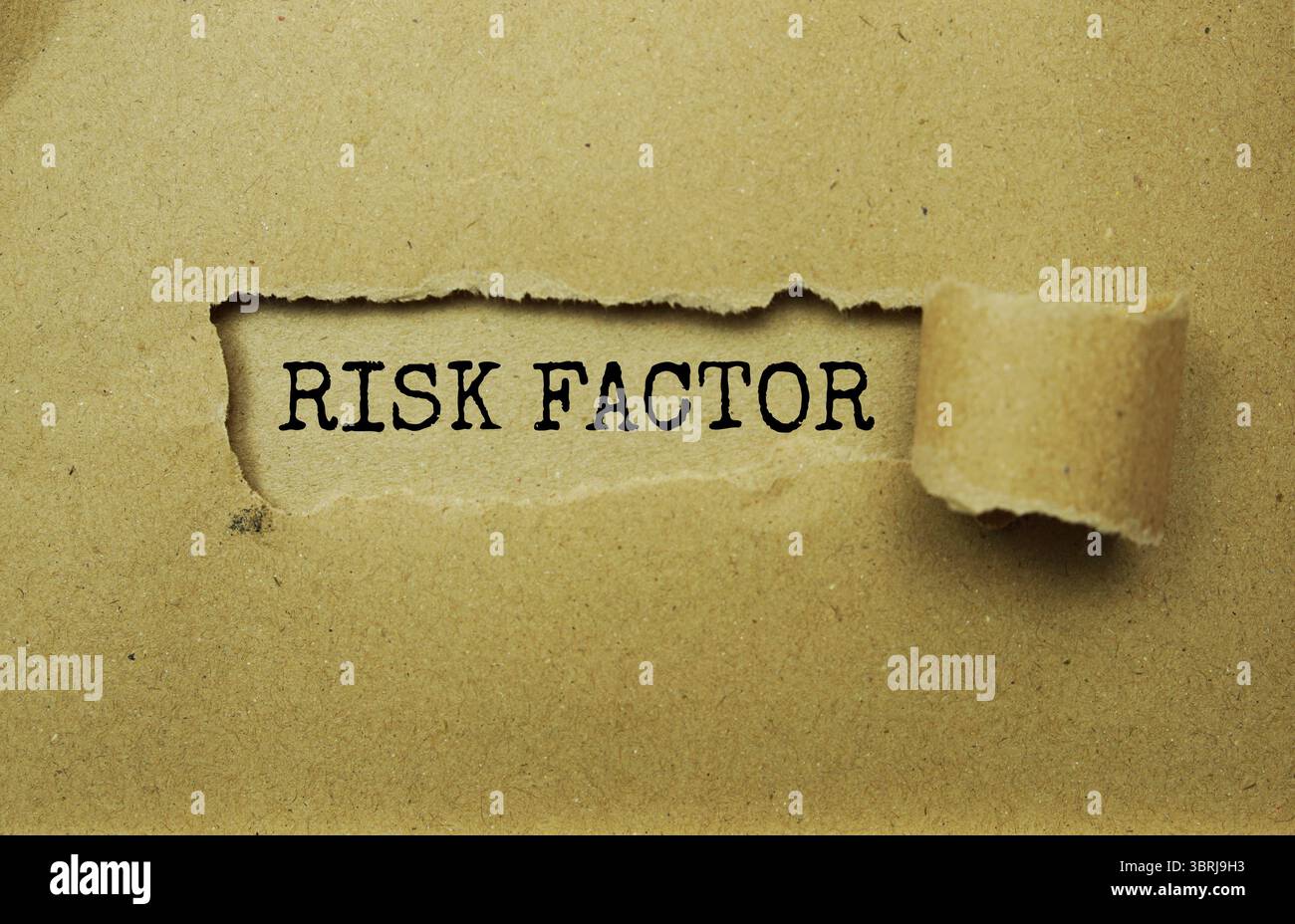 Message de facteur de risque écrit sur du papier artisanal avec un fond de papier déchiré Banque D'Images