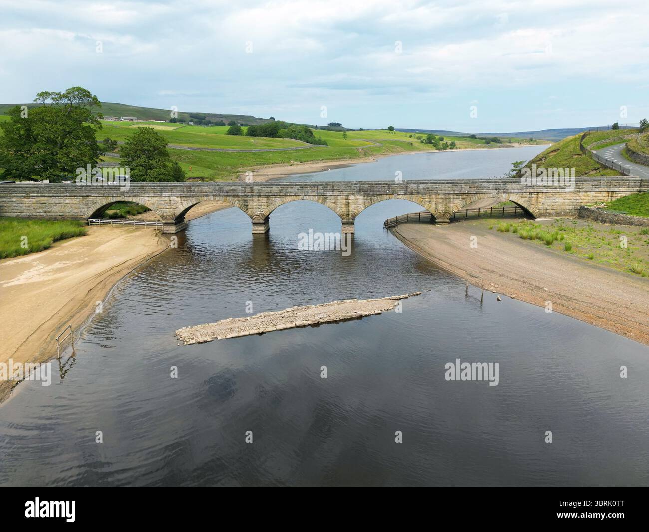 Réservoir Grassholme, Teesdale, comté de Durham, Royaume-Uni. 13 juillet 2025. Météo britannique. Un pont à cheval de bataille submergé en 1914 lorsque la vallée a été inondée par le réservoir Grassholme a commencé à réapparaître à côté du pont moderne alors que la canicule continue à travers le Royaume-Uni. Le pont a réapparu plusieurs fois ces dernières années après des périodes de sécheresse prolongées. Réservoir Grassholme, Teesdale, comté de Durham, Royaume-Uni. Crédit : David Forster/Alamy Live News Banque D'Images