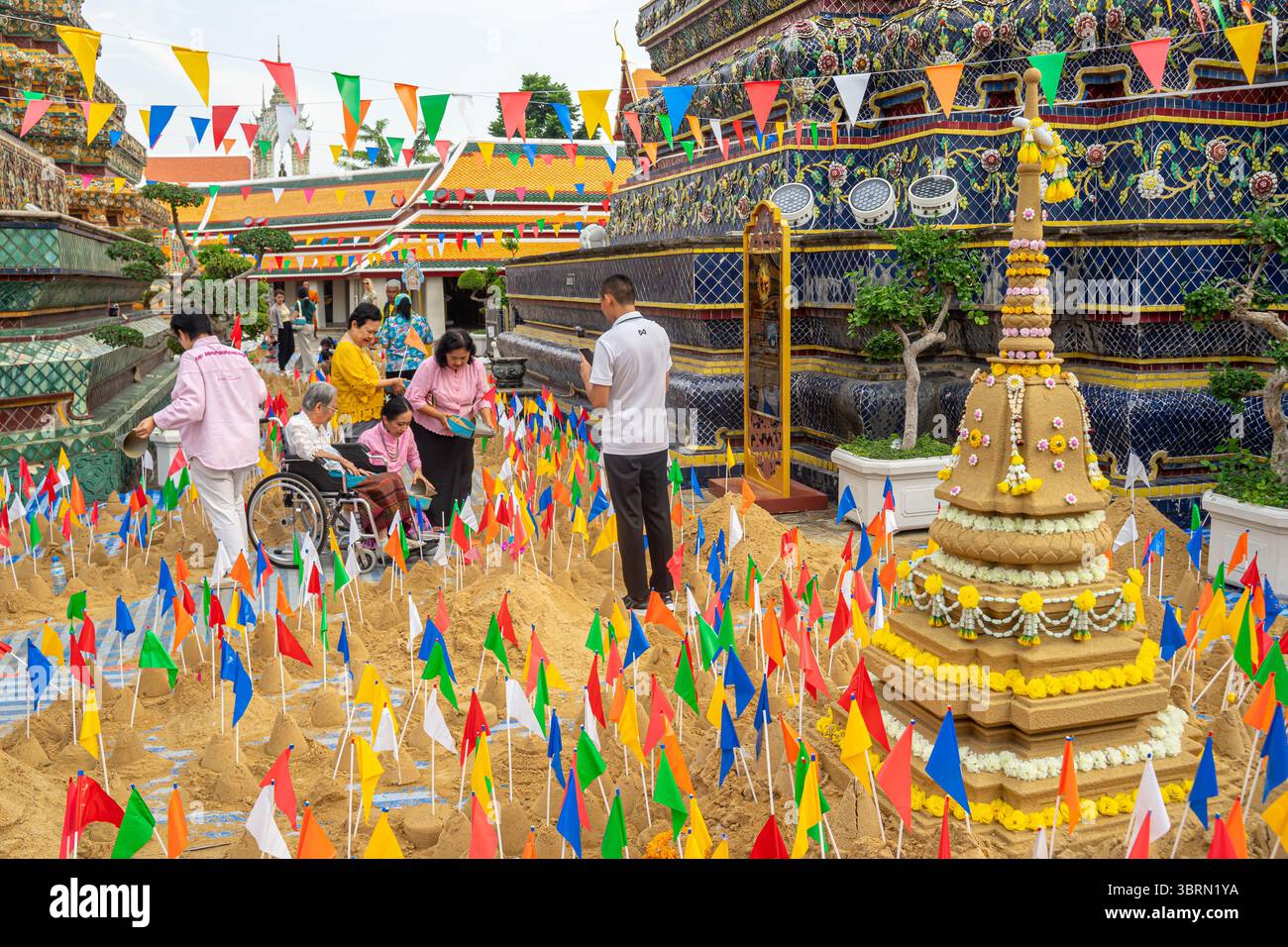 Famille thaïlandaise fabriquant des sculptures de sable avec des drapeaux pendant le festival Songkran, Wat Pho, temple Wat po, Bangkok, Thaïlande Banque D'Images