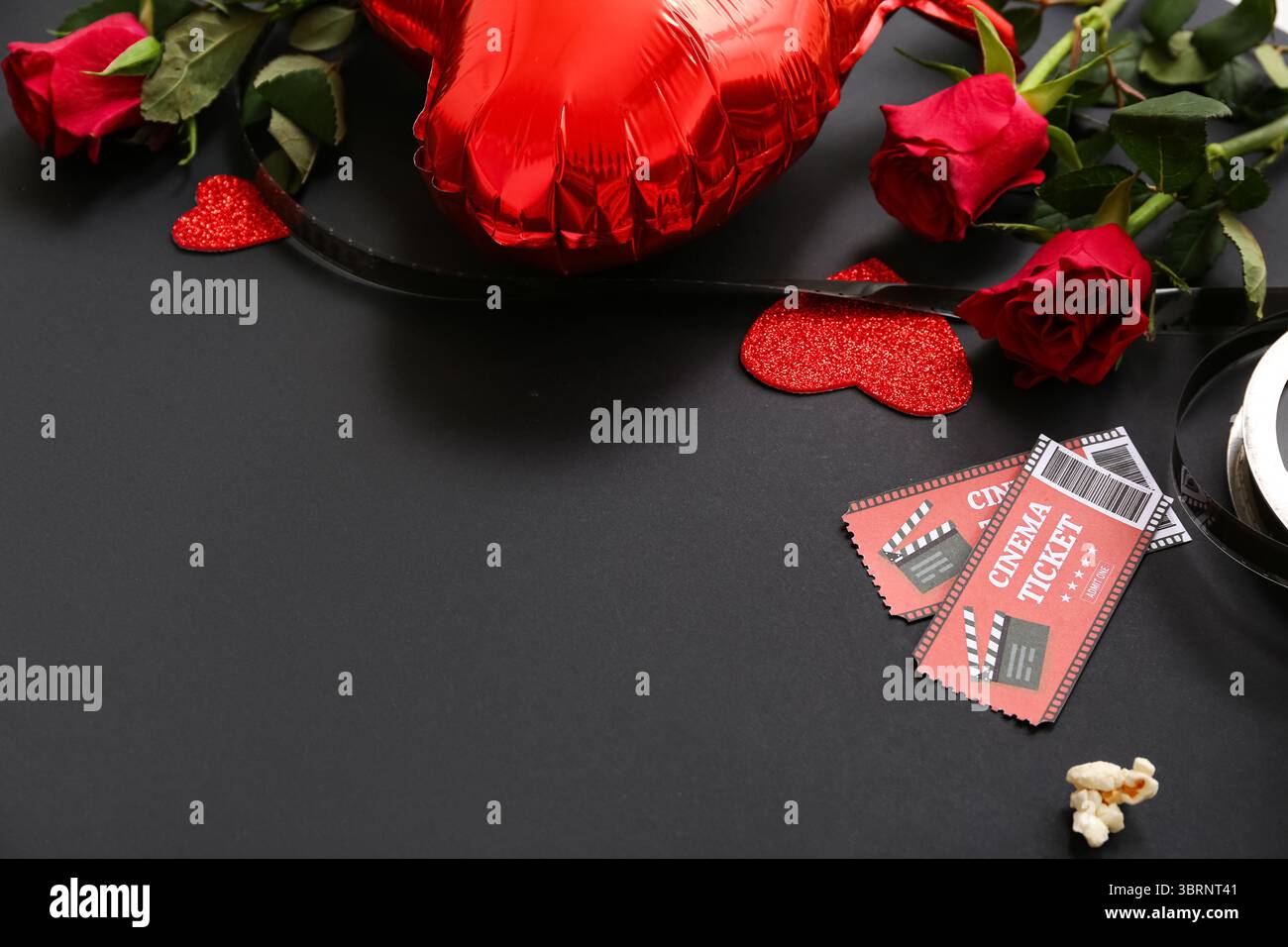 Billets de cinéma avec roses rouges et montgolfière sur fond noir. Célébration de la Saint-Valentin Banque D'Images