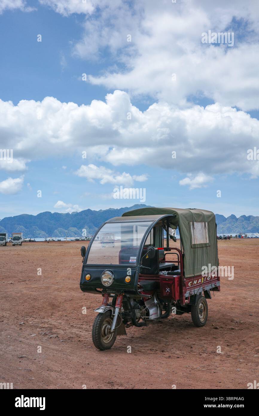 Un tricycle coloré et unique est garé sur le rivage où les transports en commun peuvent être trouvés pour transférer les voyageurs d'une ville à l'autre Banque D'Images