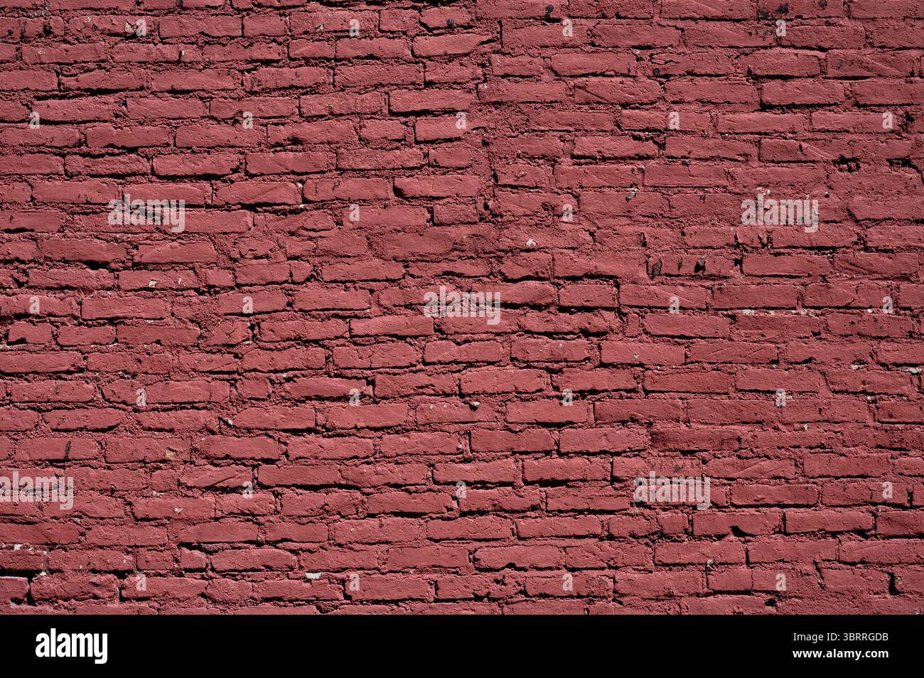 Mur de briques rouges uniforme offrant une toile de fond texturée, adapté à divers besoins de conception et de présentation Banque D'Images