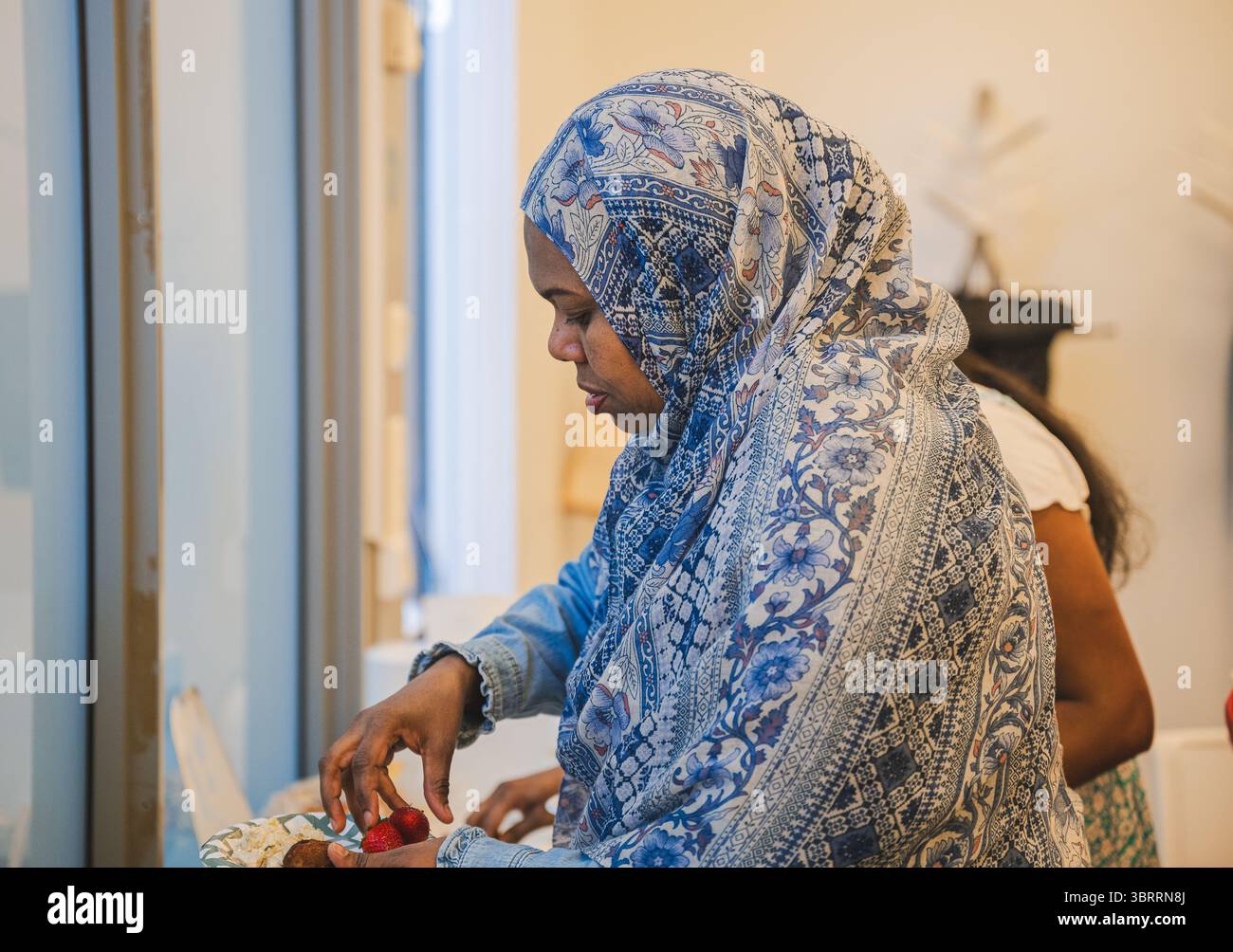 Femme musulmane en hijab prenant de la nourriture pendant le déjeuner dans un bureau moderne Banque D'Images