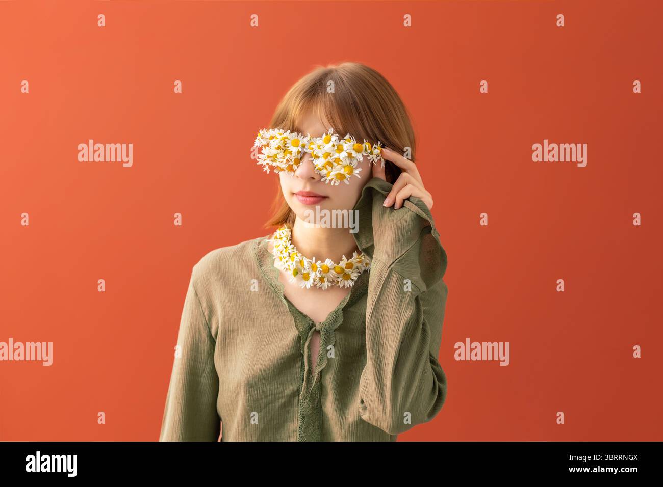 Femme touchant des lunettes à fleurs Daisy. Banque D'Images
