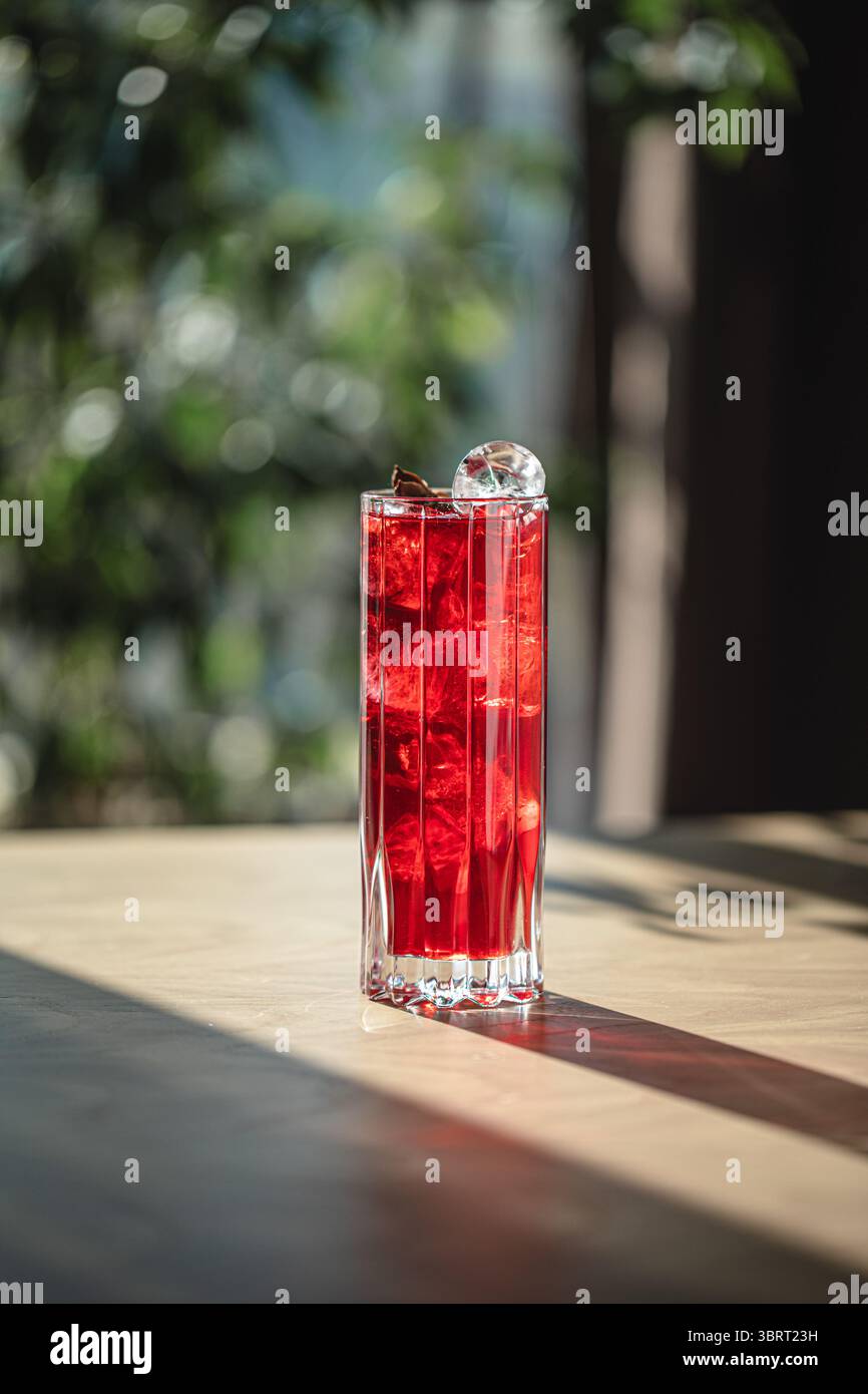 Cocktail rouge vif avec des glaçons dans un grand verre Banque D'Images