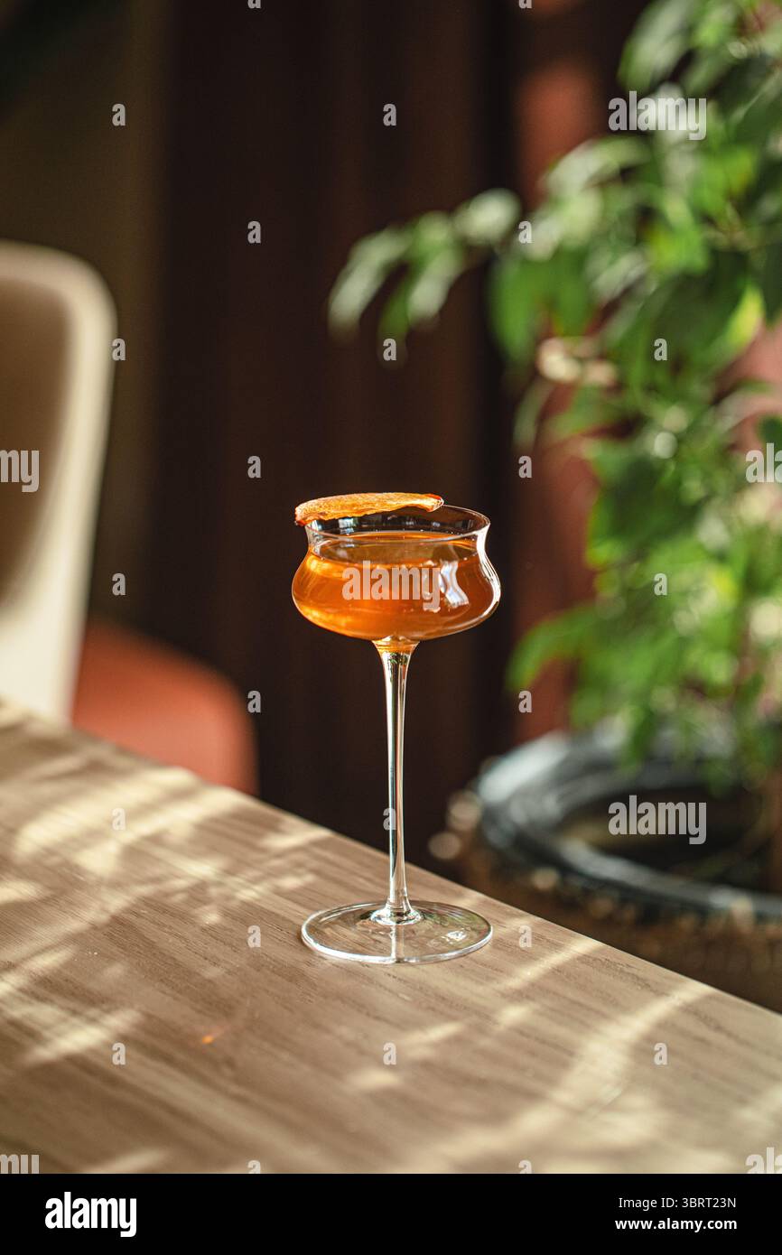 Cocktail ambre élégant sur table en bois Banque D'Images