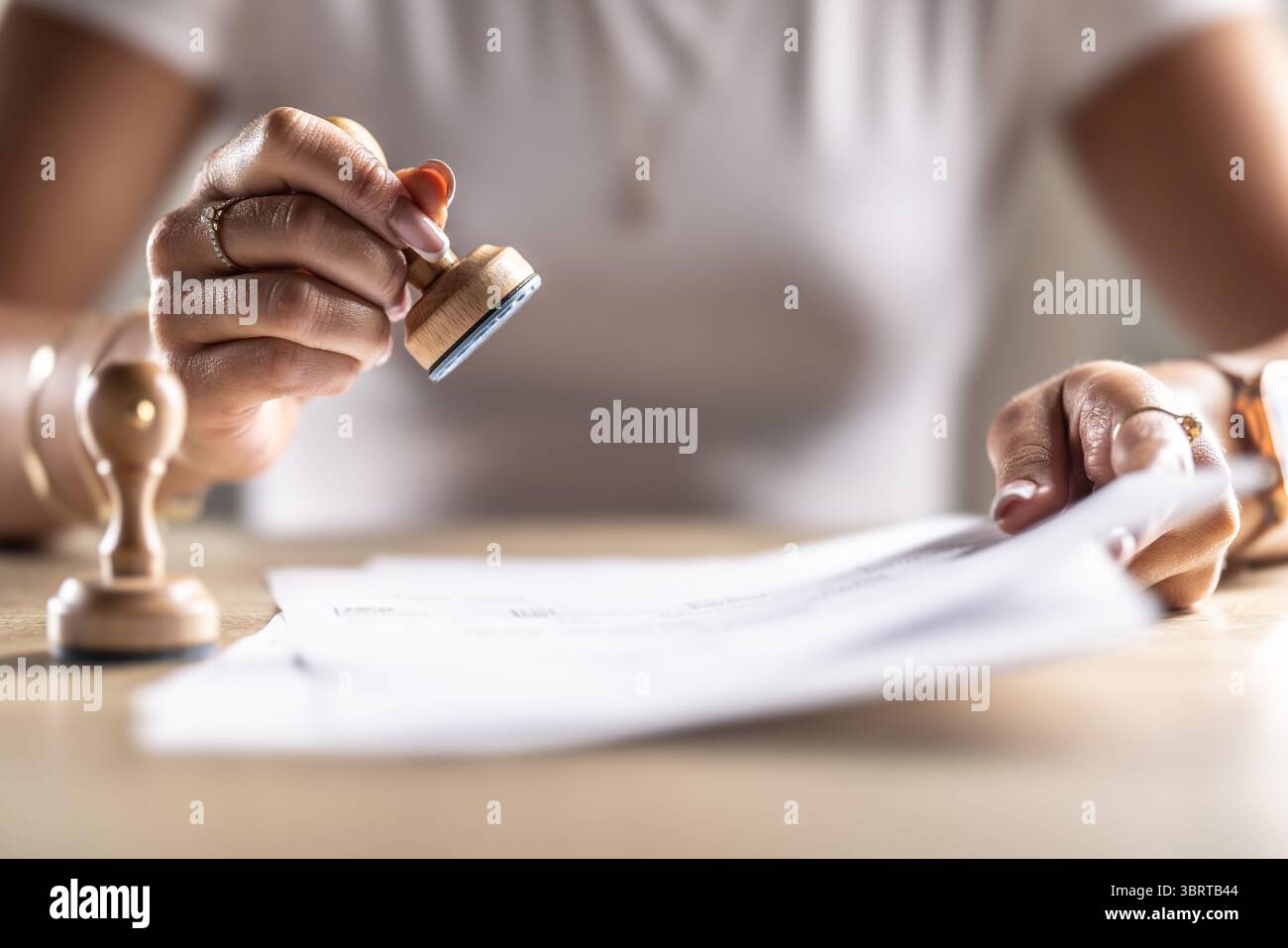 L'assistant de notaire tamponne le document archivé. Concept de permission officielle au bureau, bureau de poste, chez le notaire à la cour ou oth Banque D'Images