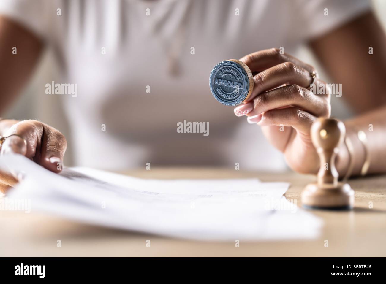 Un notaire, un juge ou un autre fonctionnaire détient un timbre qui indique approuvé. Concept de permission officielle au bureau, bureau de poste, chez le notaire à la co Banque D'Images