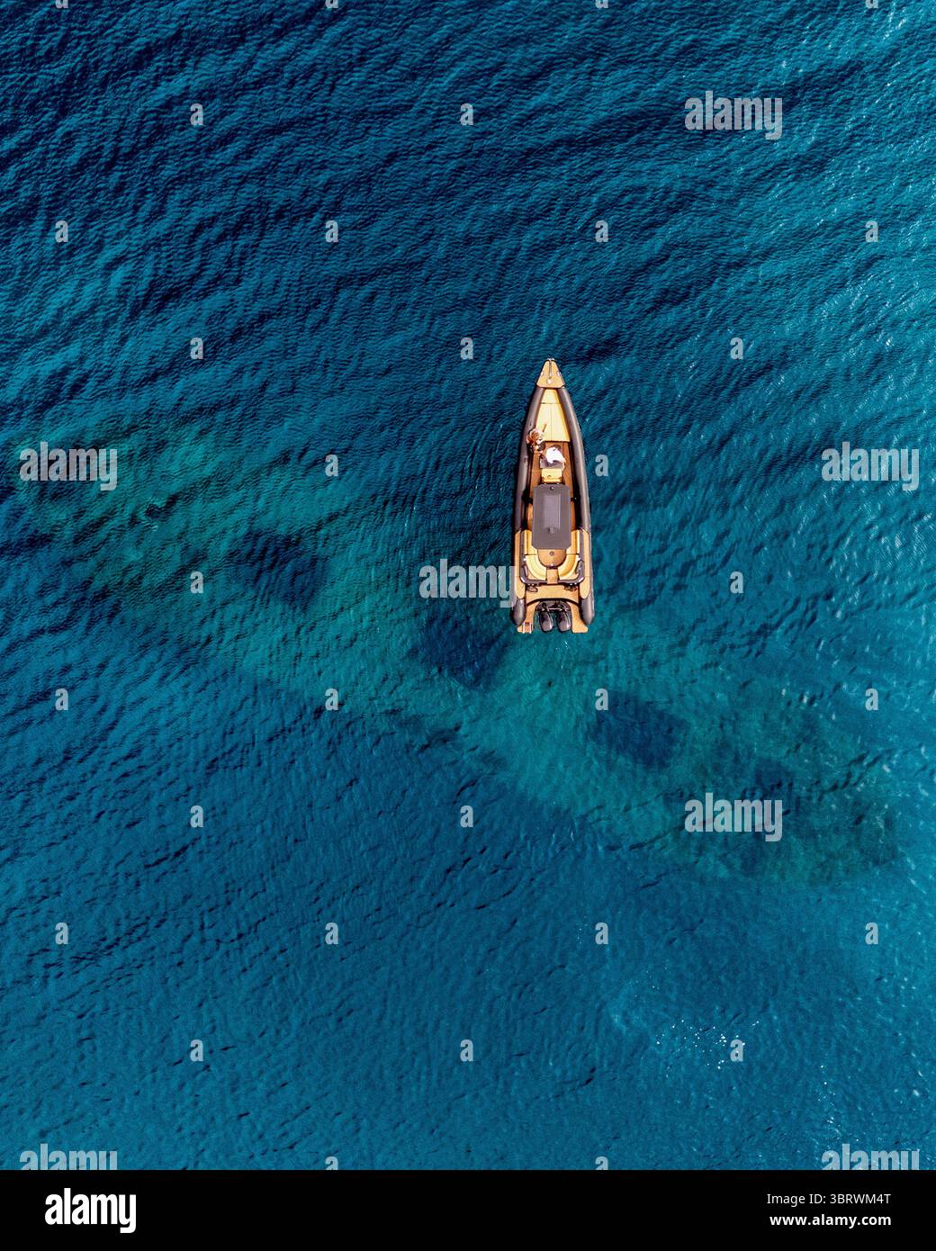 Vue aérienne d'un bateau flottant sur les eaux turquoises vibrantes près de Οδός Κάβου, Agios Georgios, Evia, Grèce. Banque D'Images