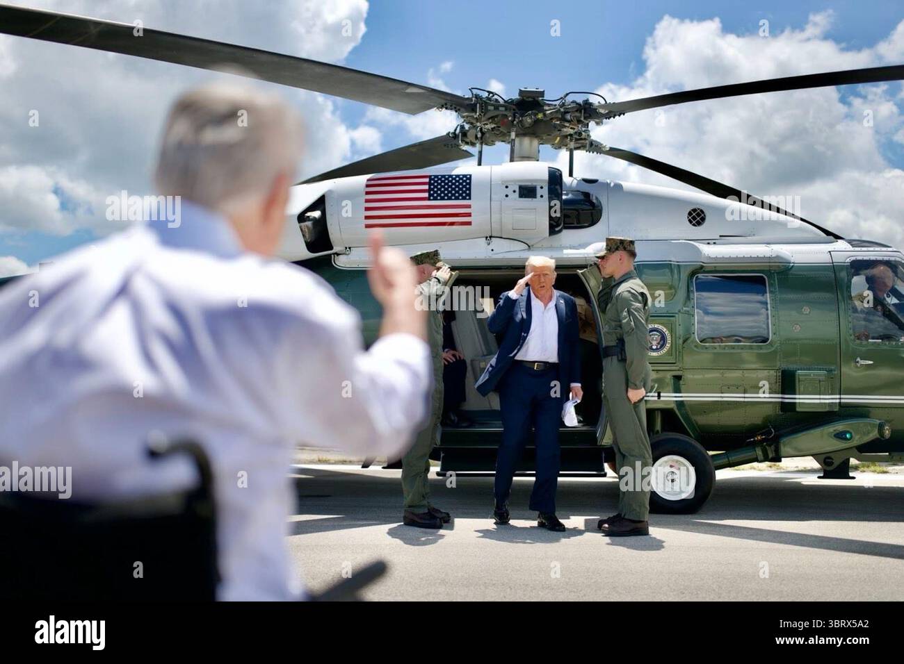 Le président Donald J. Trump salue le personnel militaire et le gouverneur Greg Abbott à son arrivée à Kerrville, au Texas, pour évaluer les dégâts causés par les inondations et rencontrer les dirigeants locaux et les premiers intervenants le 11 juillet 2025. Image reproduite avec l'aimable autorisation de la Maison Blanche. Banque D'Images