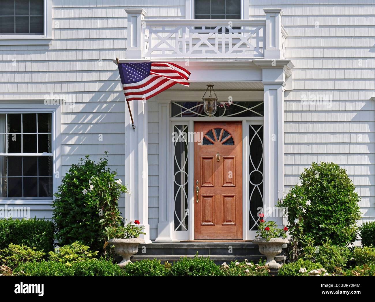 Porte d'entrée de la maison blanche de claquette avec drapeau américain Banque D'Images