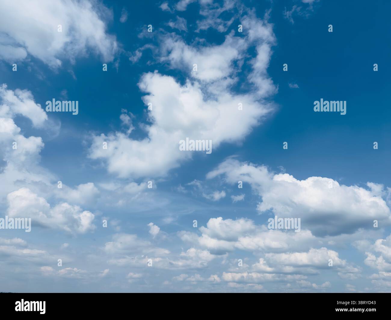 Beau ciel bleu vif rempli de nuages doux et blancs par une journée ensoleillée. Banque D'Images