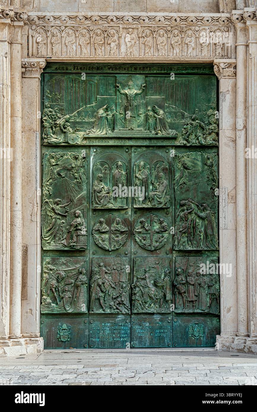 Le portail en bronze de la cathédrale Santa Maria Assunta avec des reliefs représentant des motifs récurrents dans l'iconographie chrétienne. Fermo, région des Marches, Italie Banque D'Images