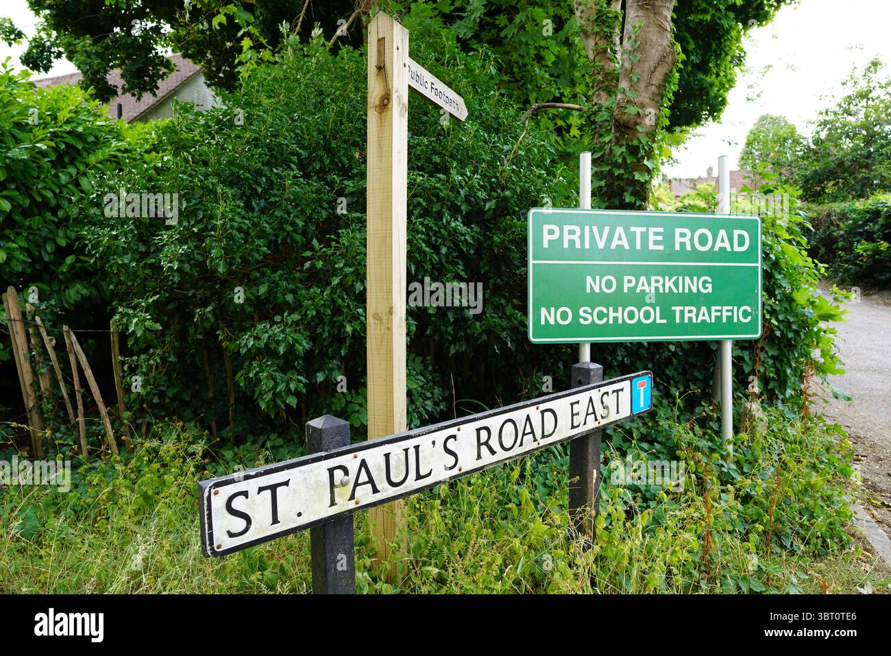 Panneau routier privé et panneau de rue parmi le feuillage vert luxuriant. Dorking, Angleterre Banque D'Images