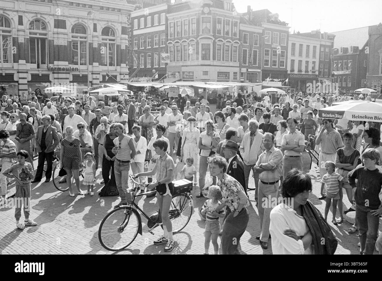 Démarrez le festival de jazz Haarlem Jazz Haarlem pays-Bas, Whizgle News, Dutch Desk, pays-Bas, 1950 - 2000 le 29-08-1985. Ces rubriques sont illustrées dans l'image. La scène est animée avec une grande foule rassemblée sur une place animée, remplie d'un éventail de personnes engagées dans diverses activités. Les individus englobent un mélange diversifié d'âges, des enfants aux adultes, tous interagissant dans l'espace ouvert. Beaucoup de gens semblent converser ou observer quelque chose qui se passe au centre du rassemblement. La toile de fond présente un éventail de bâtiments traditionnels bien conservés avec une façade complexe Banque D'Images