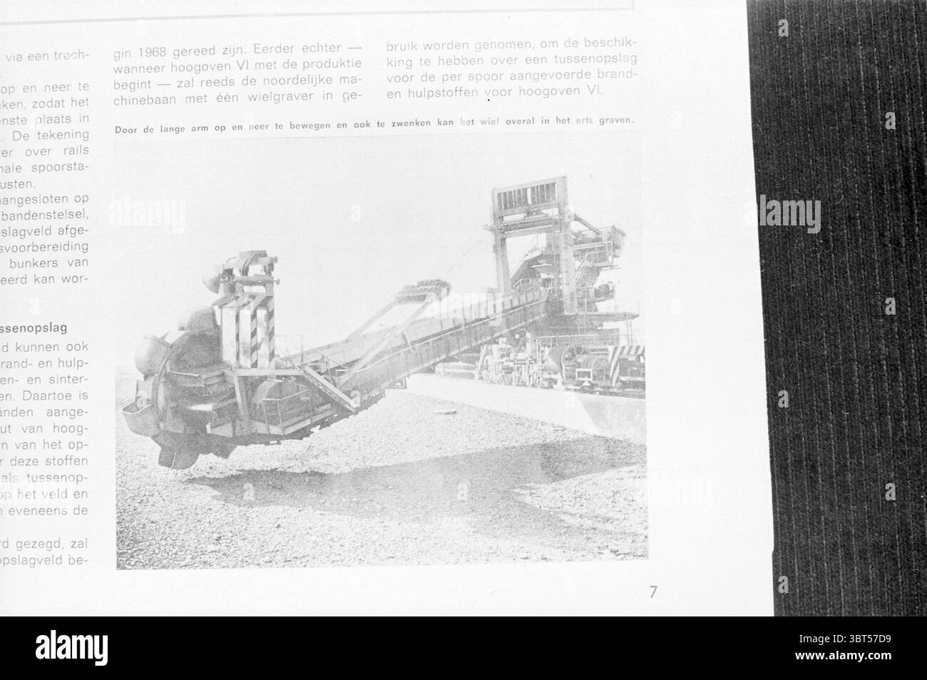 An minerai creuser machine, Whizgle News, Dutch Desk, pays-Bas, 1950 - 2000. L'image contient ces rubriques. La scène représente une grande machine industrielle conçue pour l'exploitation minière ou la construction. L'équipement est imposant, avec une structure robuste composée principalement d'éléments métalliques, mettant en valeur un éventail de pièces complexes qui semblent fonctionnelles et conçues pour les travaux lourds. L'arrière-plan présente un paysage ouvert, probablement une carrière ou un chantier de construction, avec des couches de terre et de roche visibles. Le sol est texturé, reflétant un environnement robuste et utilitaire. Banque D'Images