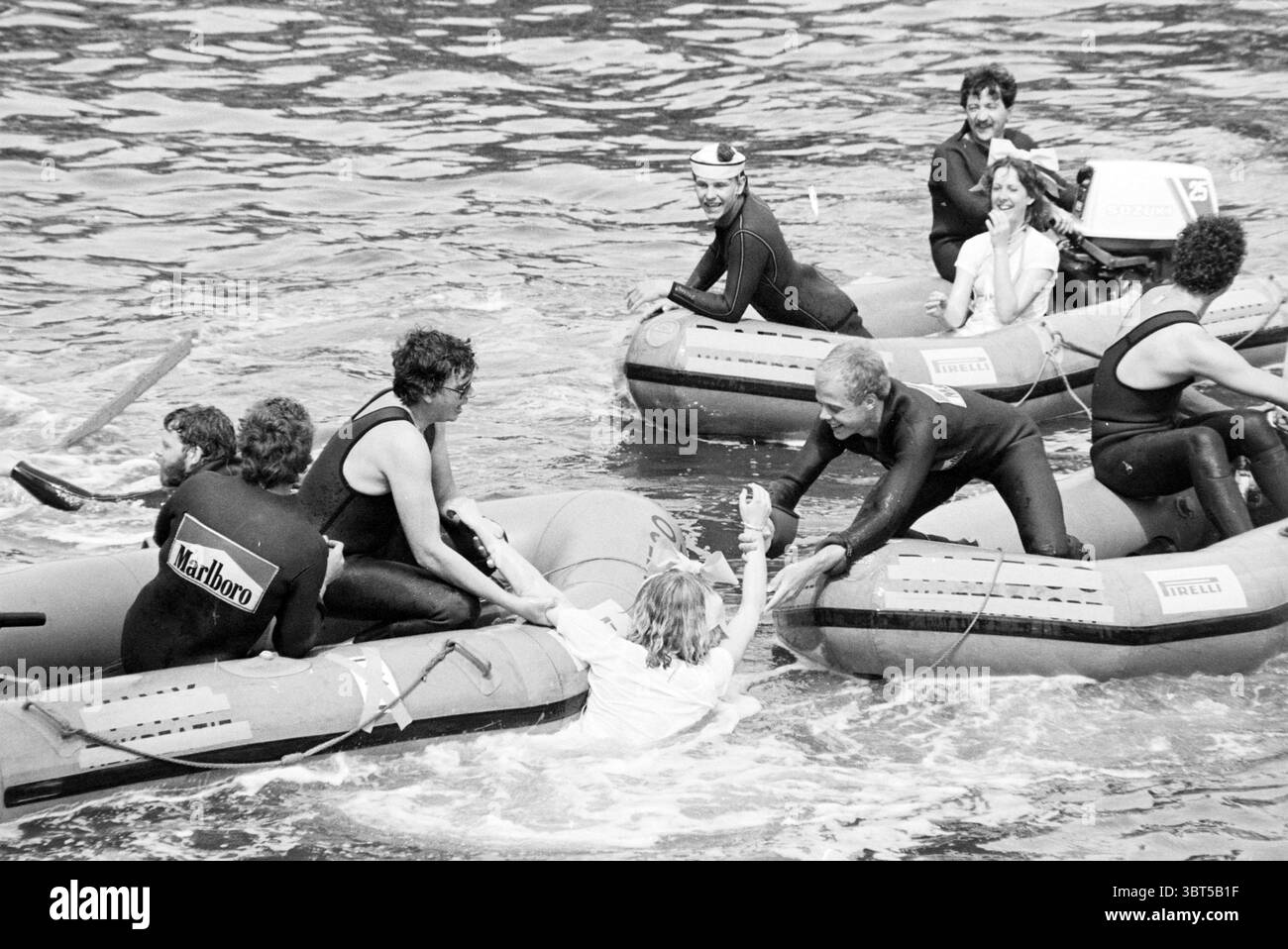 Enregistrements pour le programme sur terre, en mer et dans les airs (danse en baignoire) Gorinchem, Whizgle News, Dutch Desk, pays-Bas, 1950 - 2000 le 30-06-1979. Ces rubriques apparaissent dans l'image. La scène est vivante et dynamique, avec plusieurs petits bateaux gonflables sur un plan d'eau ondulant. Le cadre suggère probablement une rivière ou une zone côtière, avec l'eau capturant les reflets de l'environnement, améliorant la sensation de mouvement. Au premier plan, un groupe d'individus est engagé dans ce qui semble être une opération de sauvetage ou d'assistance. Une personne, une femme portant une chemise de couleur claire, atteint o Banque D'Images