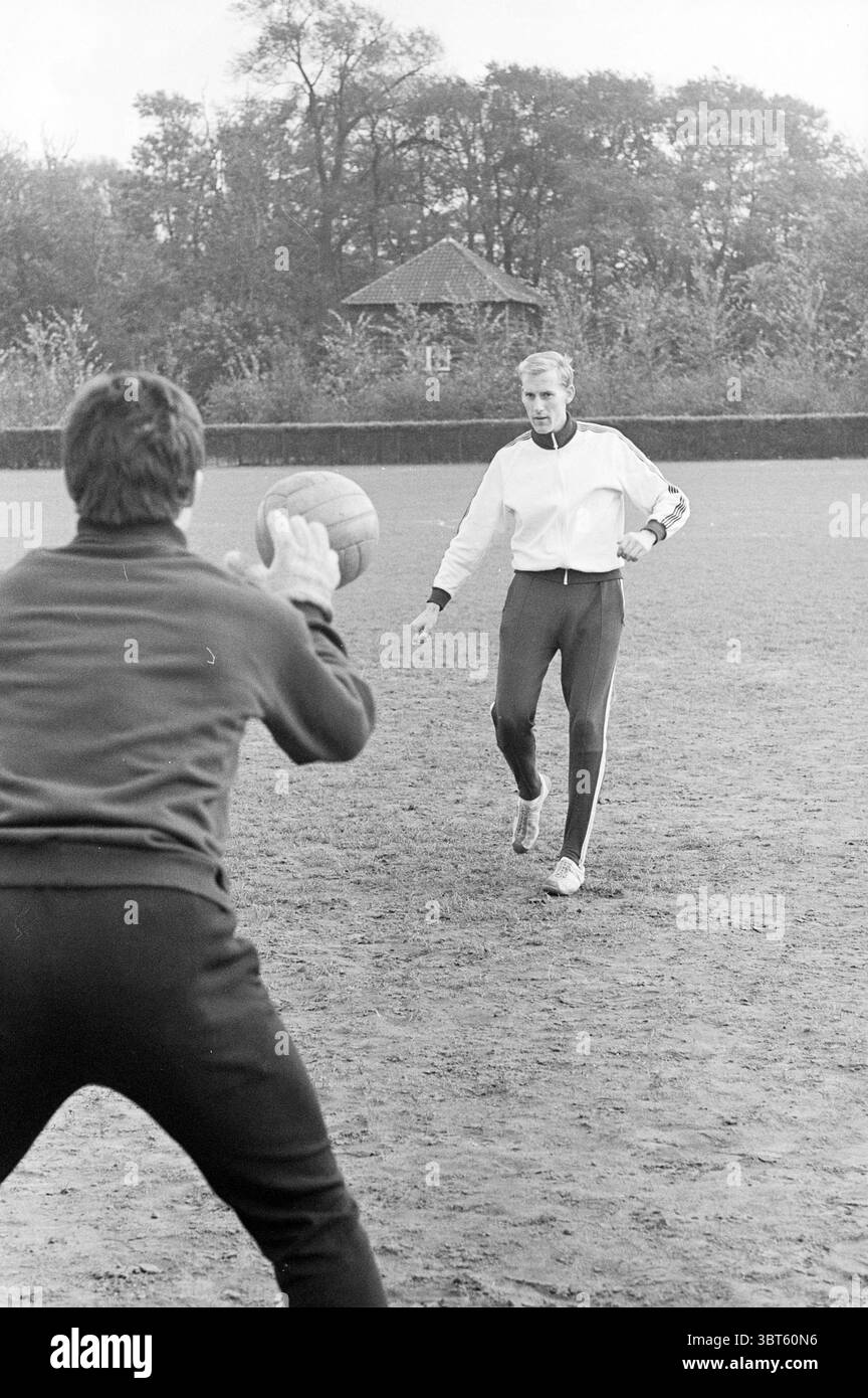 Entraîneur Telstar Rab Football Telstar, Whizgle News, Dutch Desk, pays-Bas, 1950 - 2000 on 30-10-1969. Voici les rubriques de l'image. Dans un champ herbeux ouvert, deux personnes sont actuellement engagées dans une séance de pratique. Le cadre est entouré d'arbres luxuriants en arrière-plan, contribuant à une teinte verte naturelle, tandis que le sol semble légèrement humide, suggérant qu'il a peut-être plu récemment. Une personne, vêtue d'une veste blanche légère zippée et d'un pantalon sombre, se tient prête à recevoir un laissez-passer. Sa position est confiante, avec un pied en avant, et il affiche une expression concentrée. Le de Banque D'Images